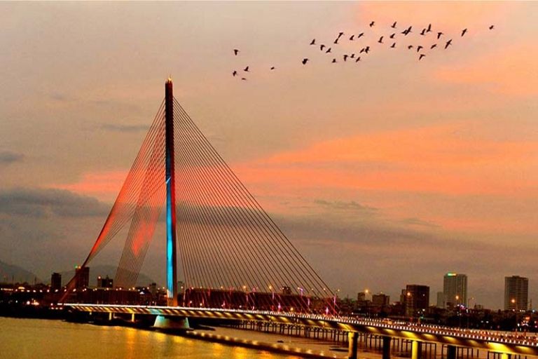 Cầu Trần Thị Lý về đêm với hệ thống dây văng chiếu sáng lung linh, phản chiếu xuống mặt sông Hàn.