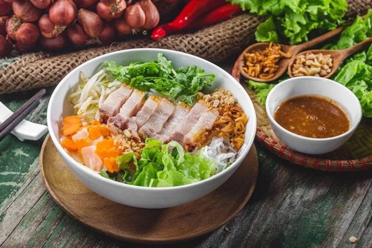 Tô bún mắm nêm đầy đủ với bún tươi, thịt heo luộc, nem chua, chả giò, tai heo và rau sống, trộn đều với mắm nêm.