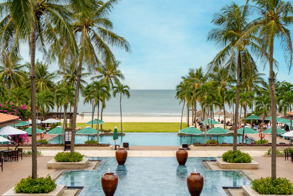 Space overlooking the coastline, green grass, and the main pool of The Ocean Terrace